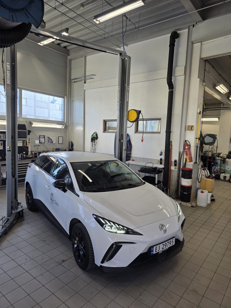 Hvit elbil i verkstedhallen hos Ødegården Auto