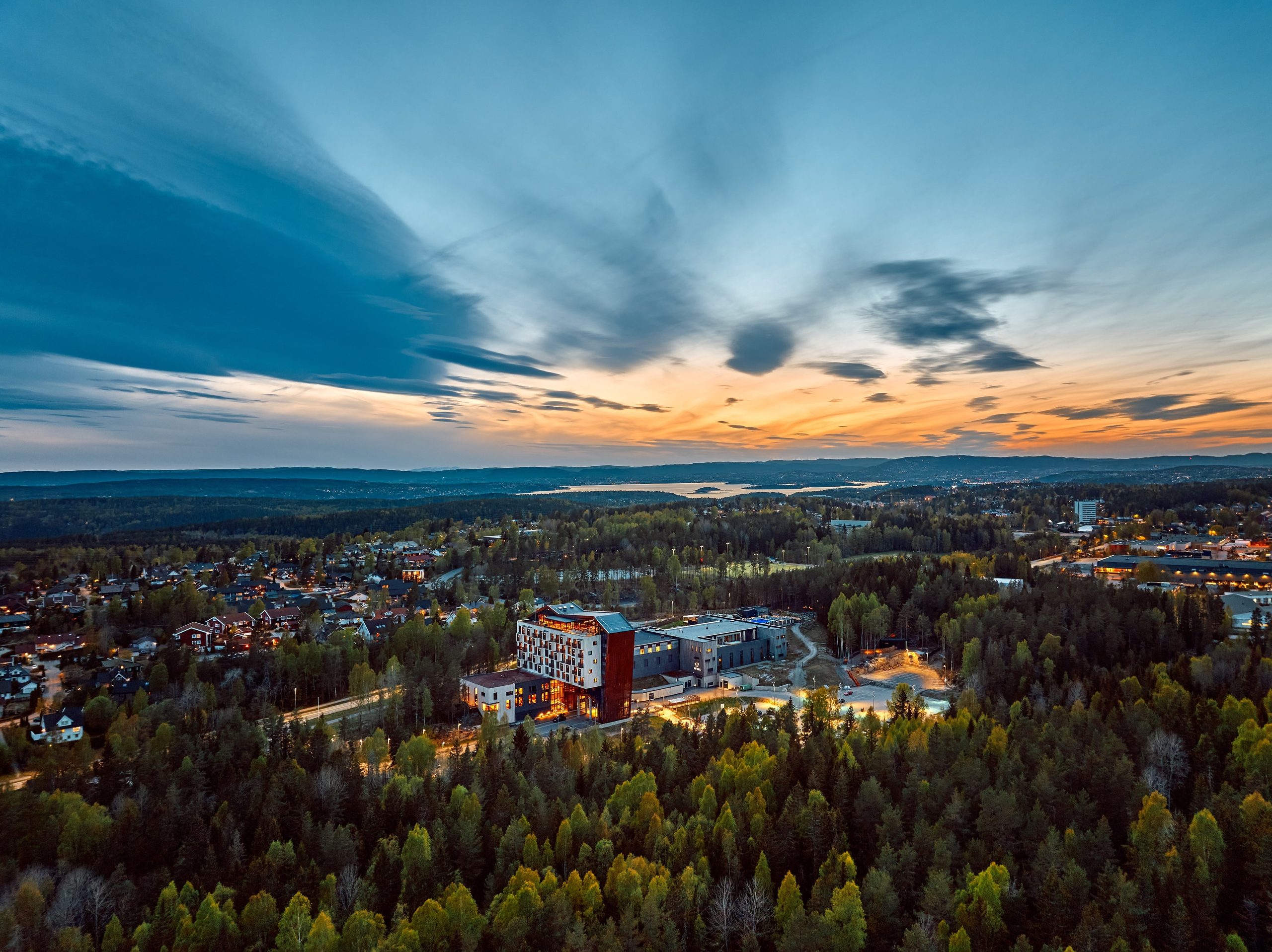 The Well sett fra lufta i solnedgang, omgitt av skog
